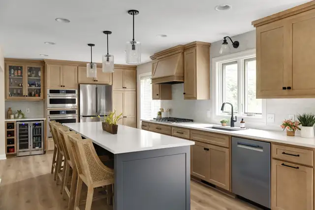 Eagan main floor kitchen remodel with natural maple cabinets, gray island with seating, wood range hood and beverage fridge