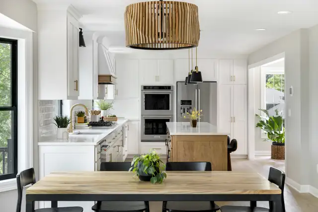Eagan kitchen remodel with white cabinets, wood drum pendant, double wall ovens and a wood dining table